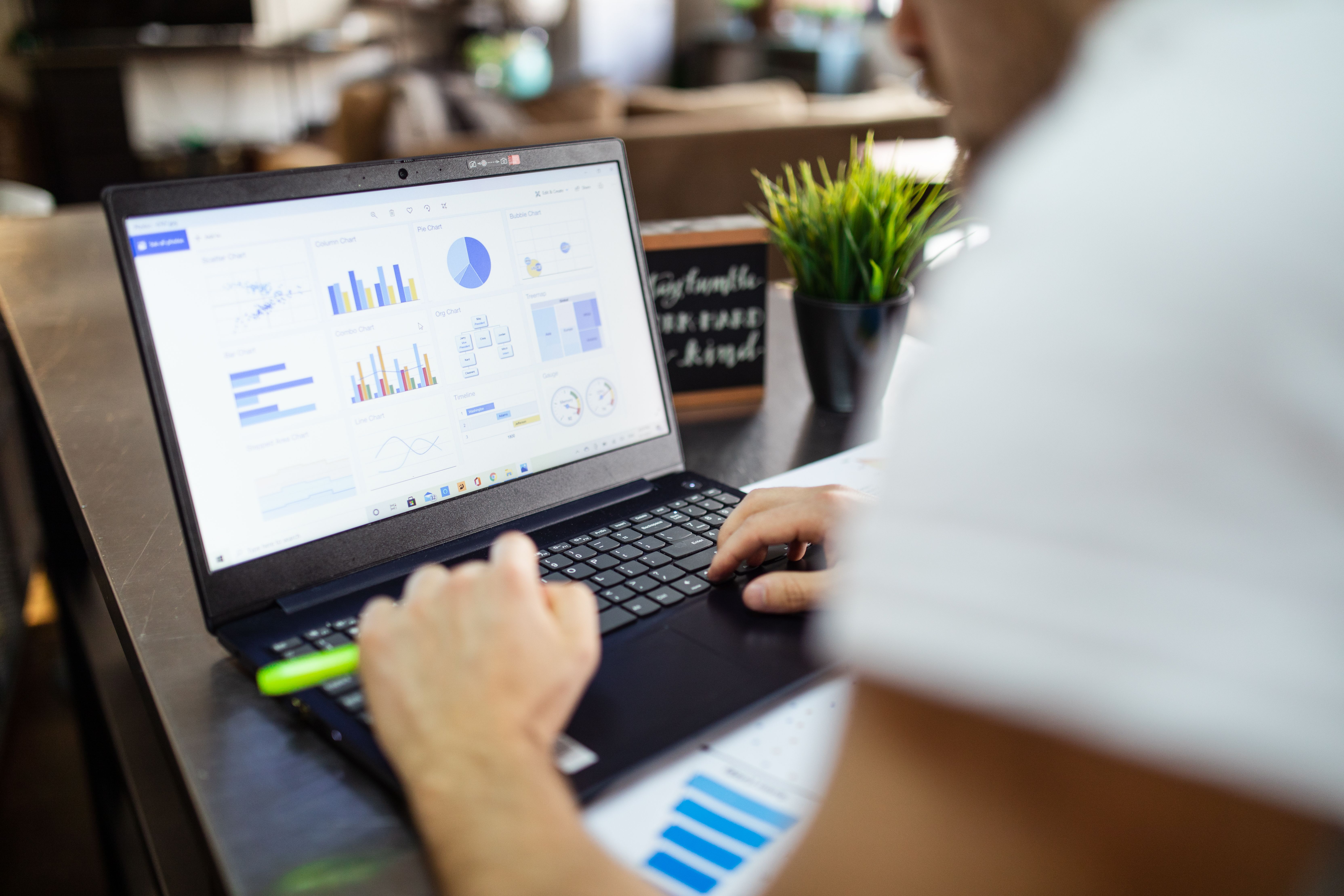 Professional reviewing charts and workflow information on a laptop